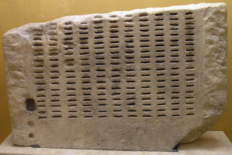 A stone marked with regular indentations.